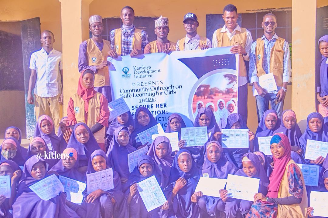 Girls holding certificates and materials at KDI outreach