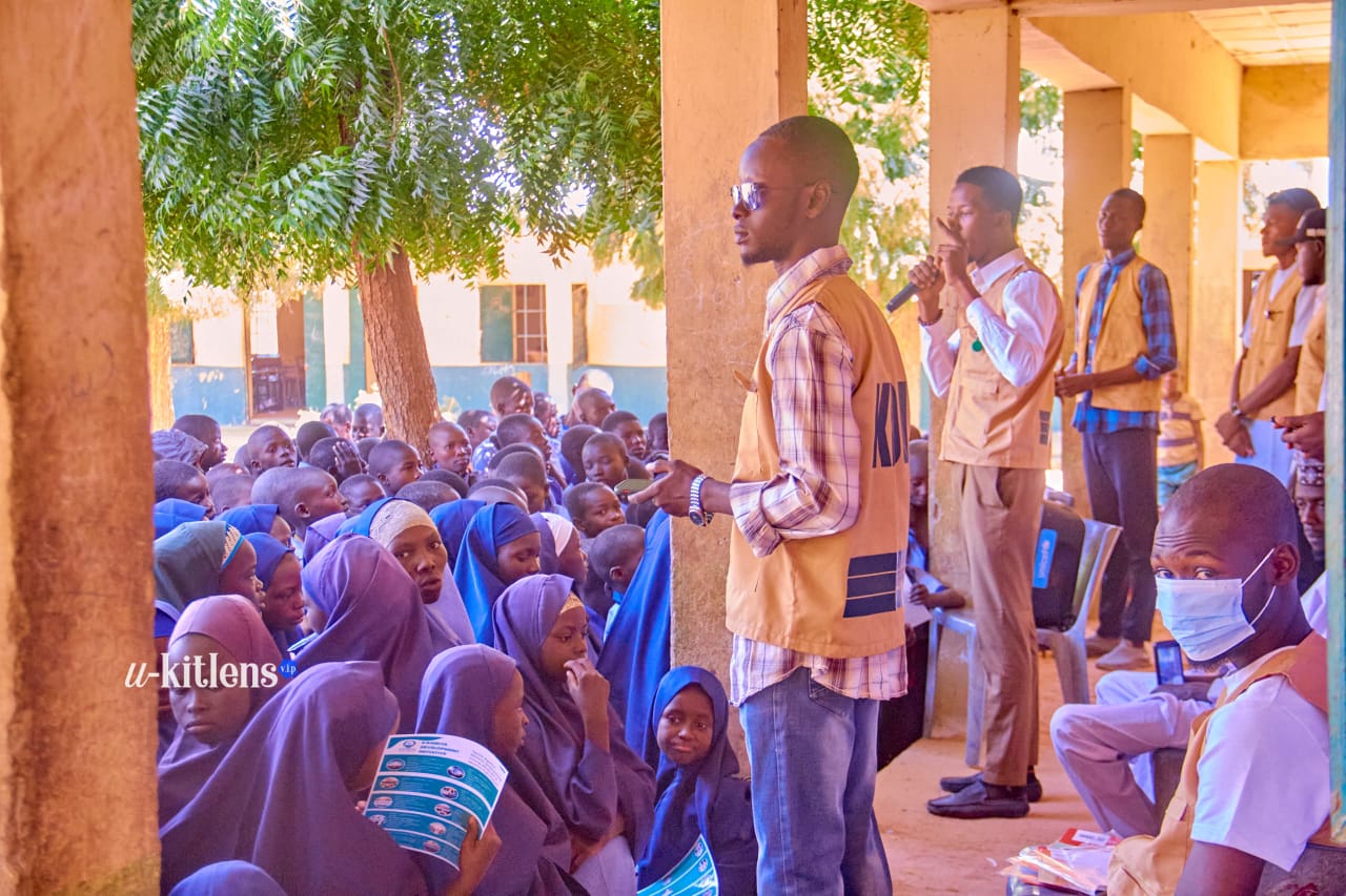 KDI volunteers addressing a large crowd of students at the malaria outreach session