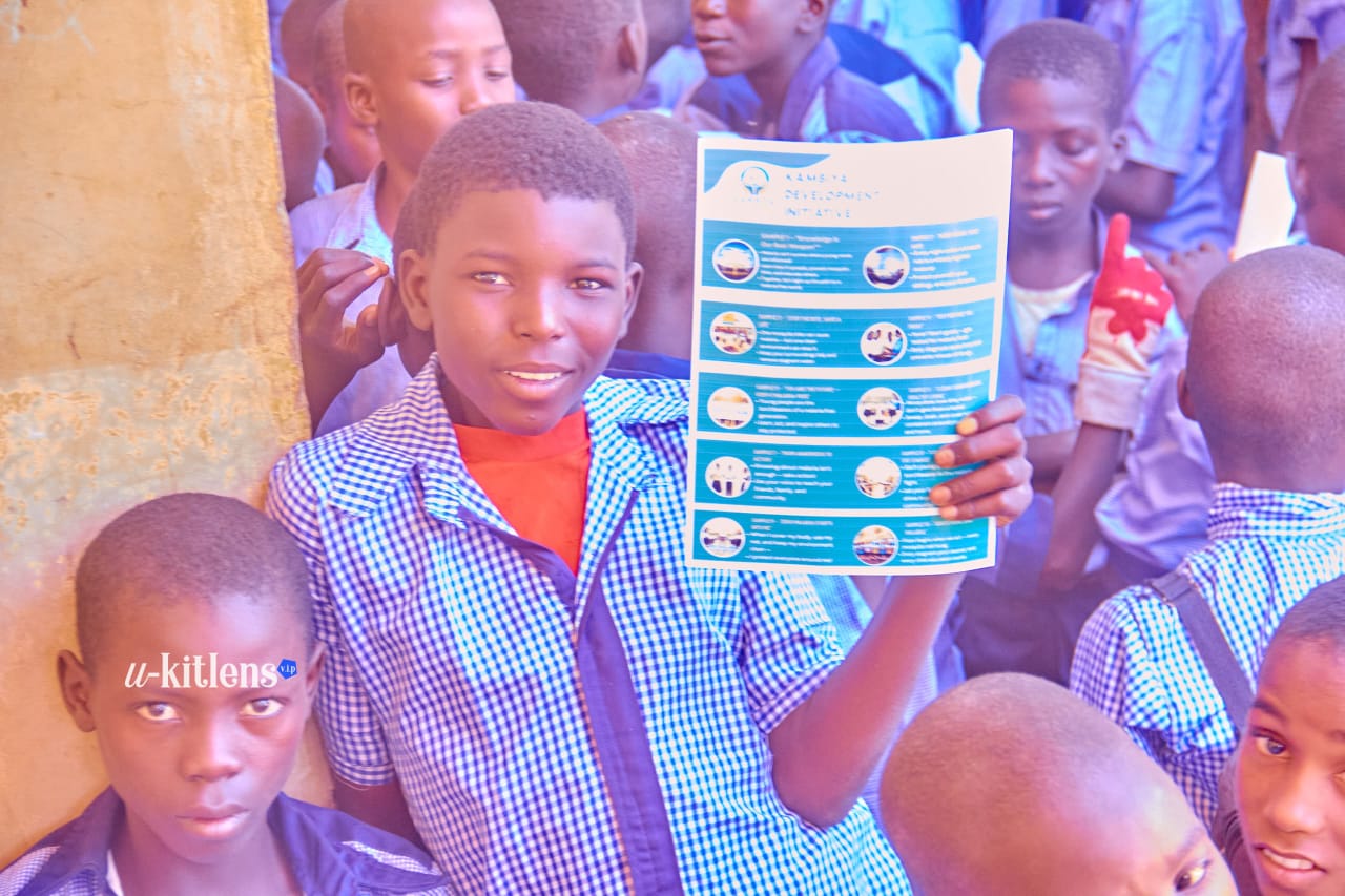 Student holding up KDI malaria prevention material during outreach