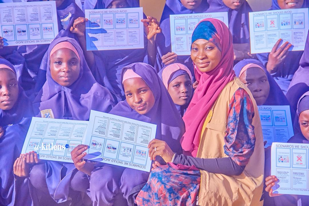 KDI volunteer with girls holding educational materials